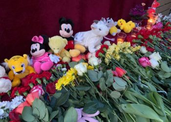 Люди несут игрушки и цветы к мемориалу в память о погибших в казанской школе